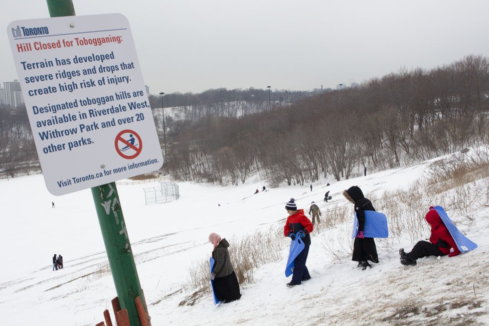 Kids get ready to slide down closed toboggan hill.