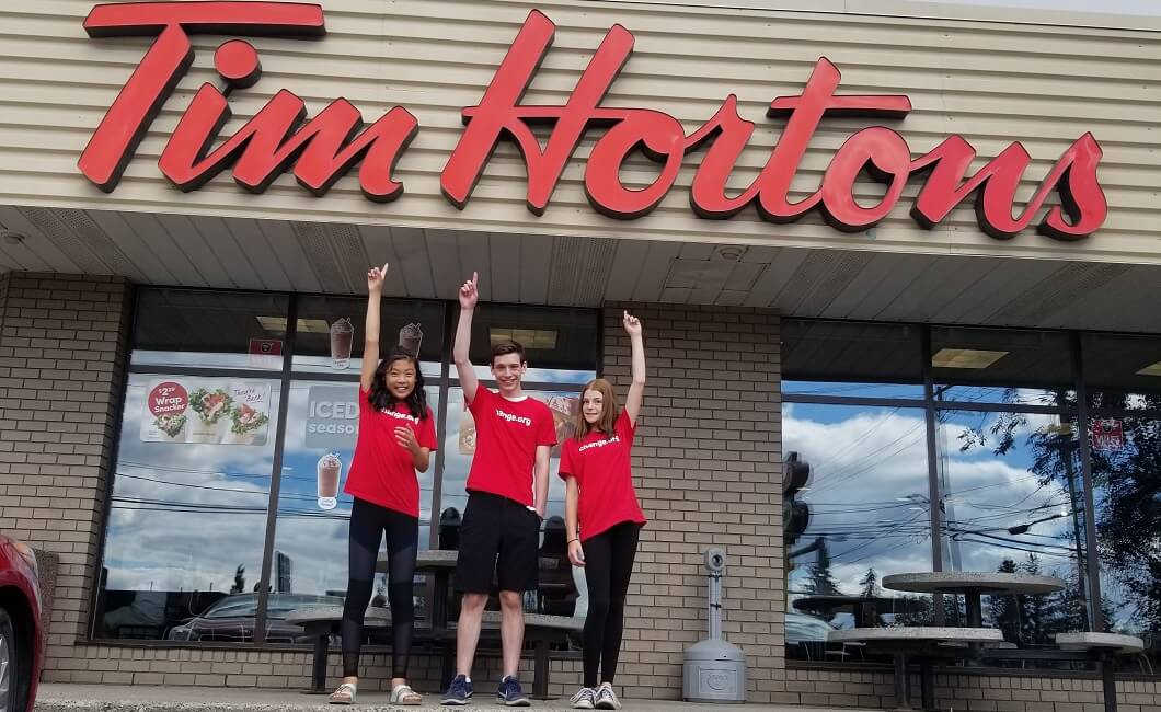 Young environmentalists in front of a Tim Hortons.