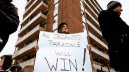 A women holds a sign declaring "an organized parkdale can win"