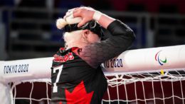 Canadian goalball team captain Amy Burk rests her head in her hand against the net during her team's match against China