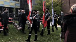 Colour guard baring three flags marching down the isle