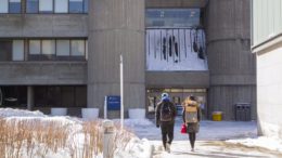 Two students with backpacks walking in the snow on the University of Toronto Scarborough campus