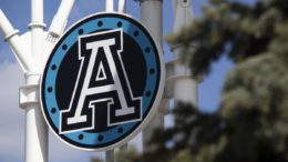 The Toronto Argonauts sign at BMO Fieldlogo is obscured by a coniferous tree outside of the arena.