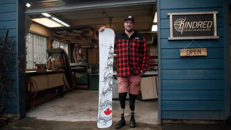 Tyler Turner posing with his snowboard