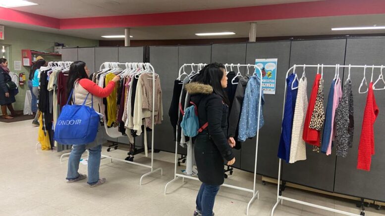 People look through clothes on racks at a Swapaholics clothing-swap event