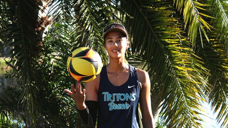 Kitana Lim of Eckerd College volleyball smiles under a palm tree with a ball.