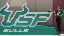 Hallie Bryant posing next to the USF sign at the team's facility