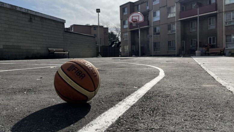 Basketball left on a outdoor basketball court.