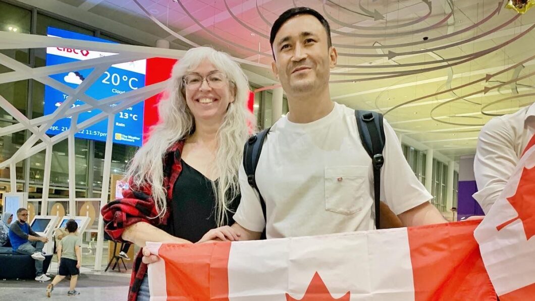 People holding Canadian flags at the airport.