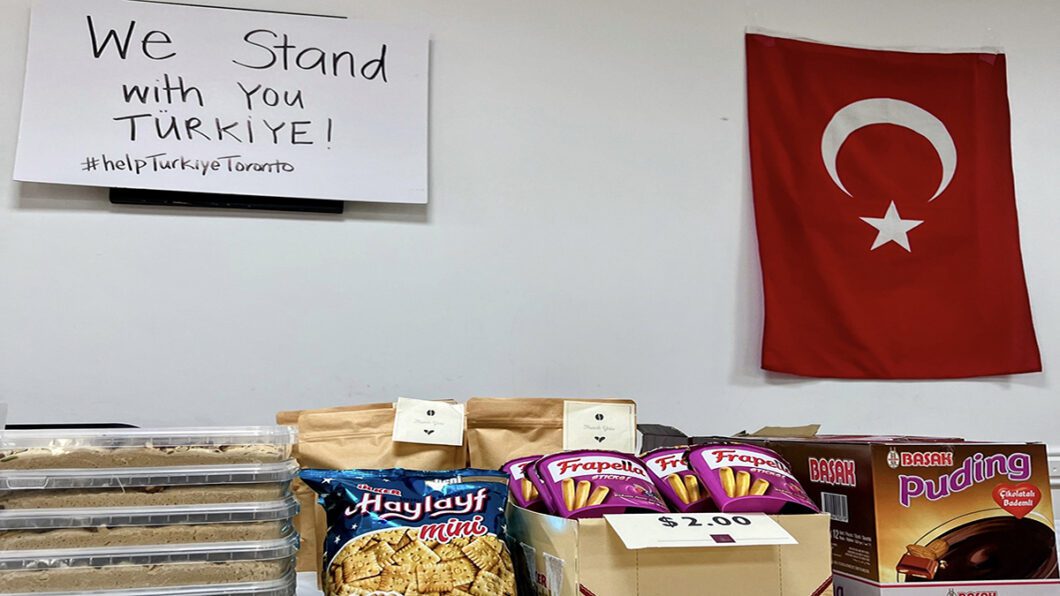 Turkish snacks on a table with a flag and a sign hanging above.