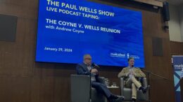 Paul Wells and Andrew Coyne are seated on stage in an interview for a live podcast taping of The Paul Wells Show.