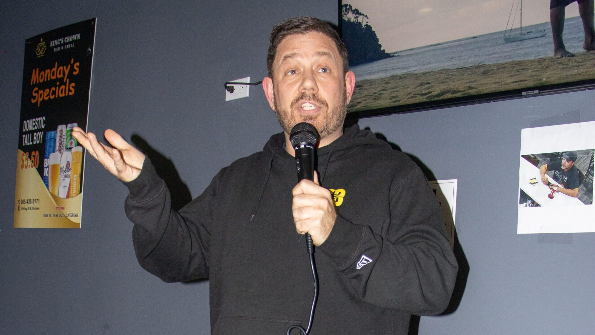 Comedian Paul Schmidt performs in front of a grey wall