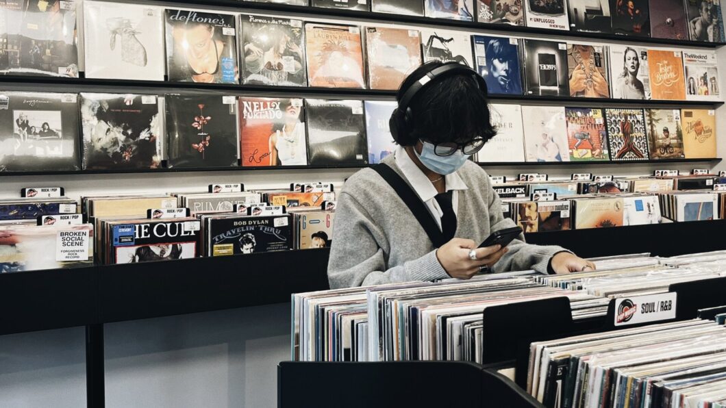 A vinyl record collector is browsing through the records at Pop Music.