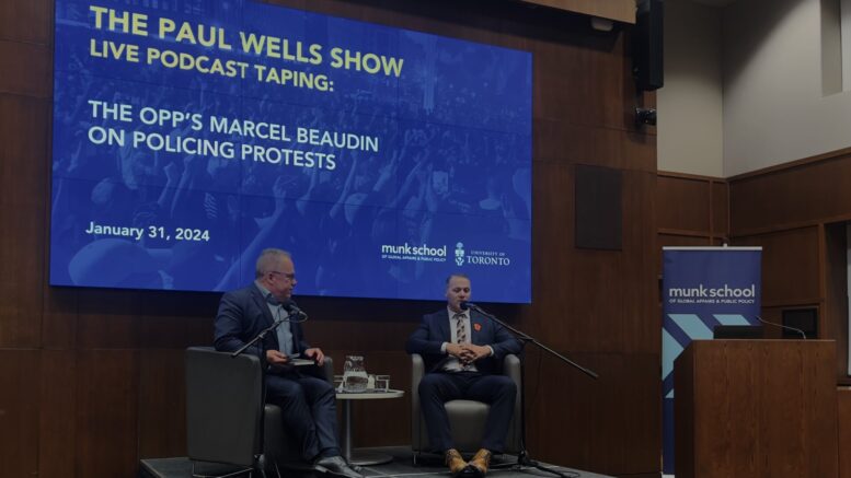 Ontario Provincial Police Acting Supt. Marcel Beaudin (right) at the Paul Wells show podcast taping hosted by Paul Wells (left) on Jan. 31, 2024, in Toronto, Ontario. (Melanie Kalogirou/Toronto Observer) 
