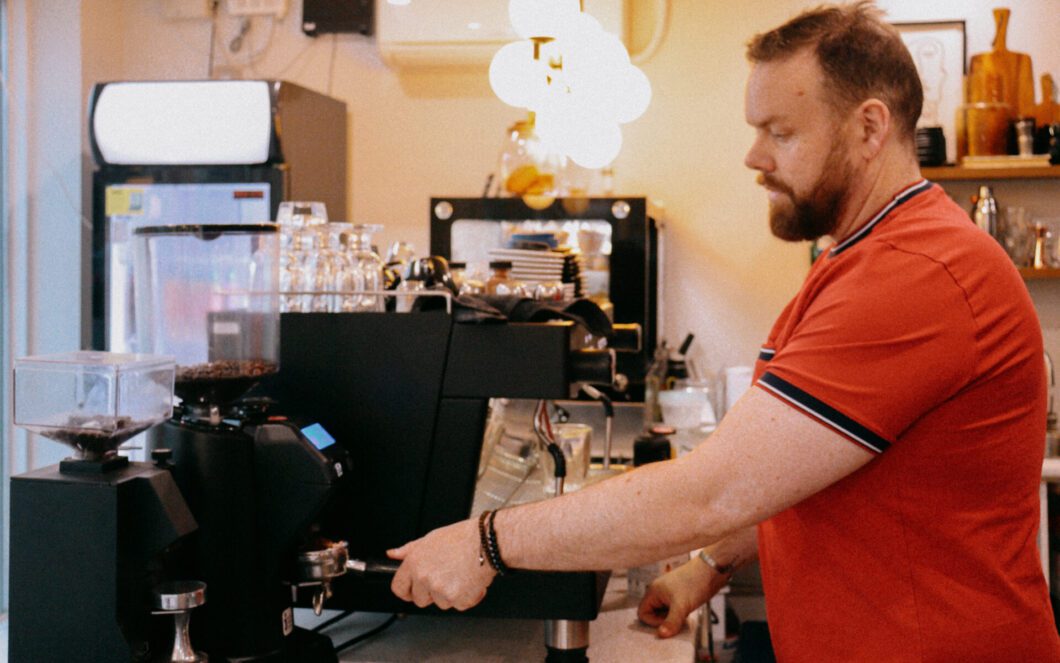 The barista is setting up the coffee machine. 