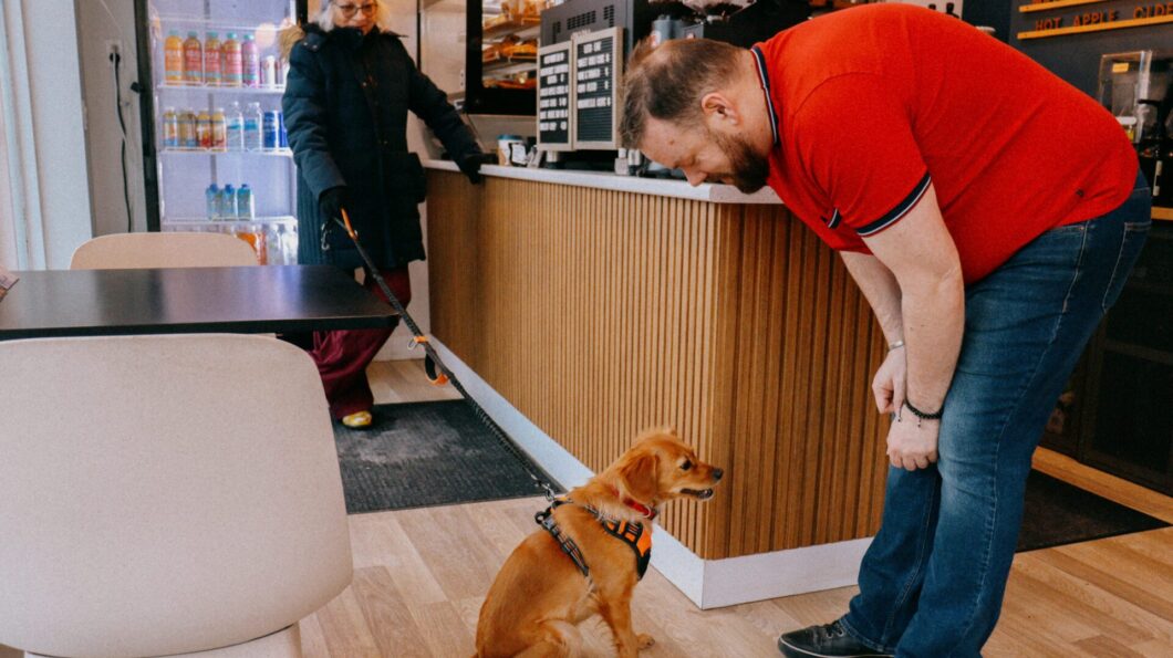 James Thompson, the owner and barista of Oliver Coffee Bar greets a dog with her owner. 