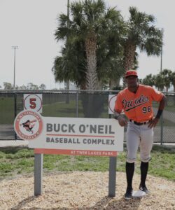 Thomas Sosa poses beside a sign that reads Buck O'Neil Baseball Complex.