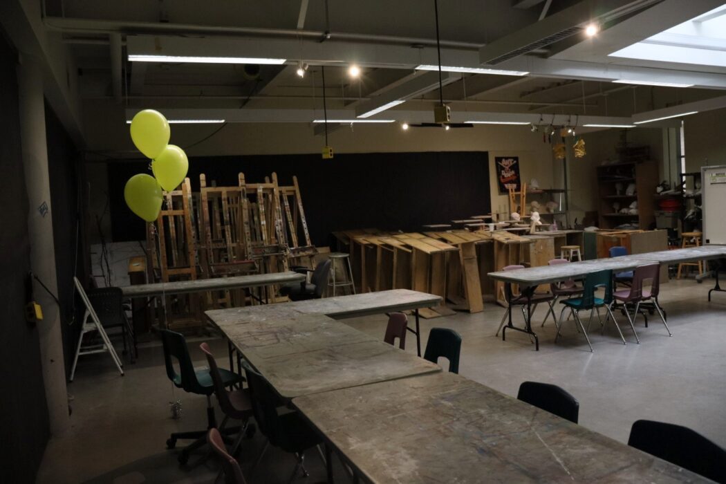 Lone Centennial college coloured themed balloons are displayed in the empty art studio room.