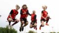 Savannah Campbell (right), a quadball player, jumps with her teammates on June 8, 2024, at Esther Shiner Stadium in Toronto. Quadball is a sport inspired by quidditch, the fictional sport where witches and wizards fly through the air on broomsticks in J.K. Rowling’s Harry Potter series. (Haruka Ide /Toronto Observer)